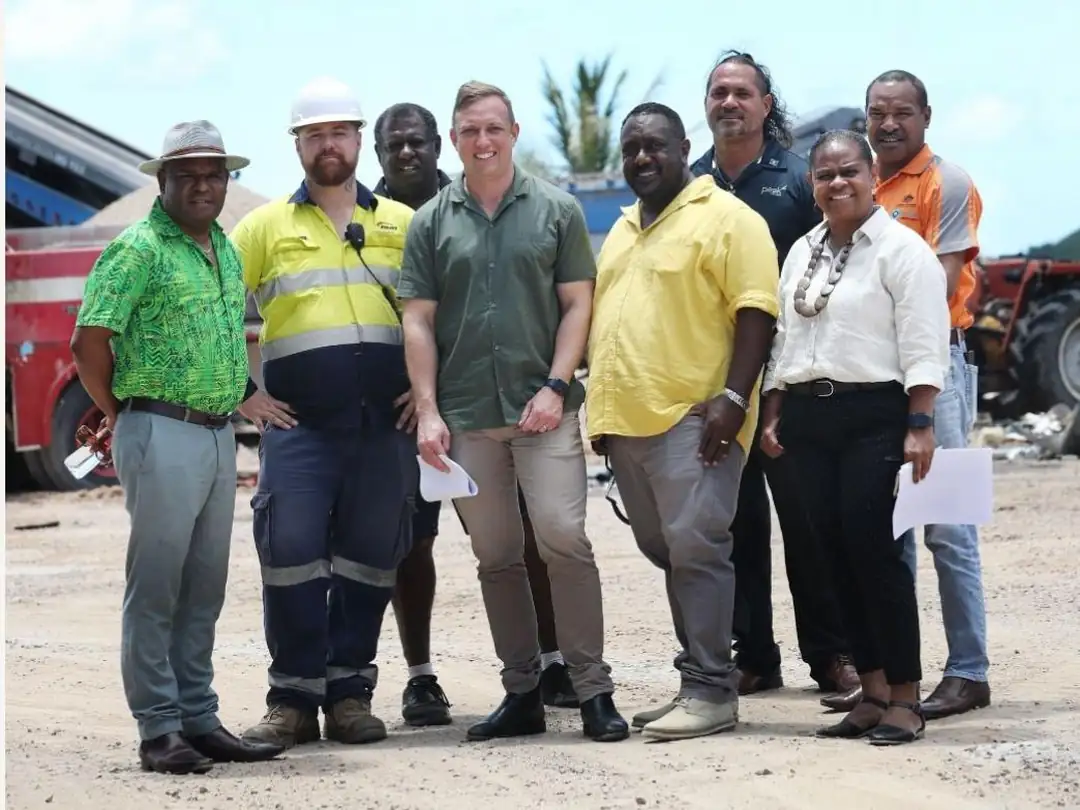 Crystal Ailan crew in high-visibility workwear standing with visiting industry and government representatives at the Badu Island site.