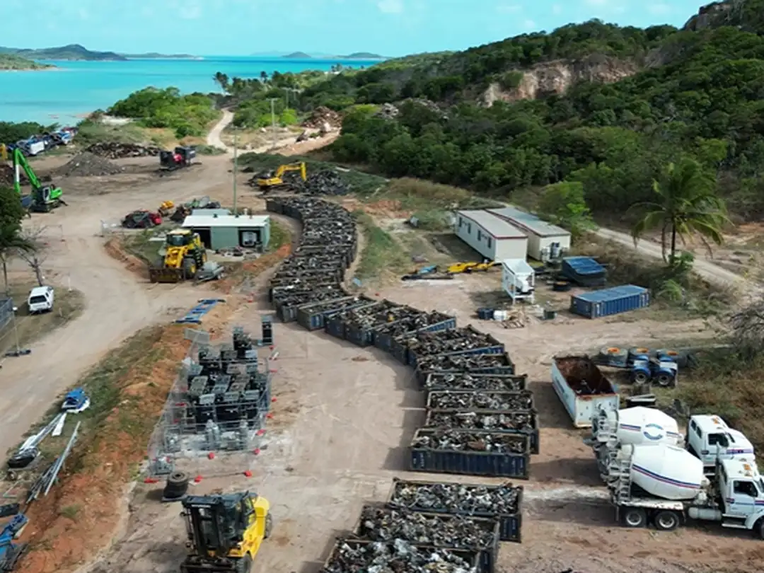 Aerial view of the Crystal Ailan material recovery yard, with sorted stockpiles, trucks and plant beside the coast.