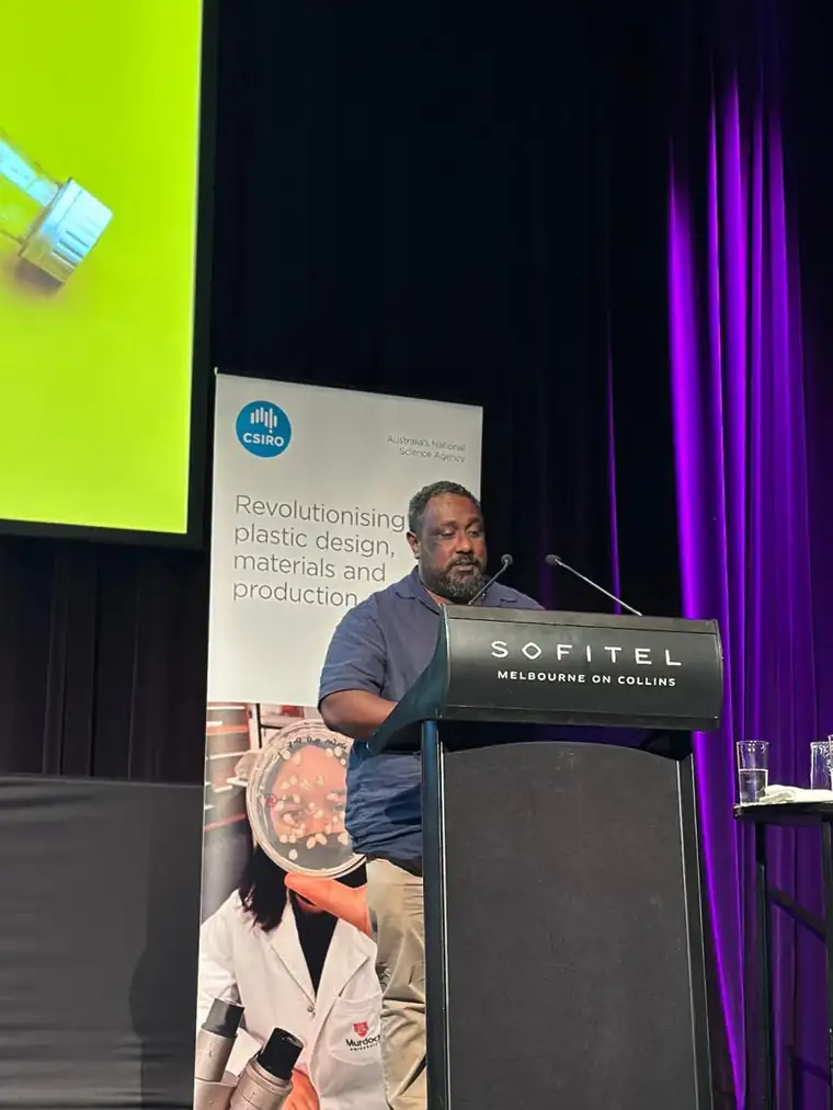Edmund Tamwoy speaking from a lectern at a CSIRO session on revolutionising plastic design, materials and production, at the Sofitel Melbourne on Collins.